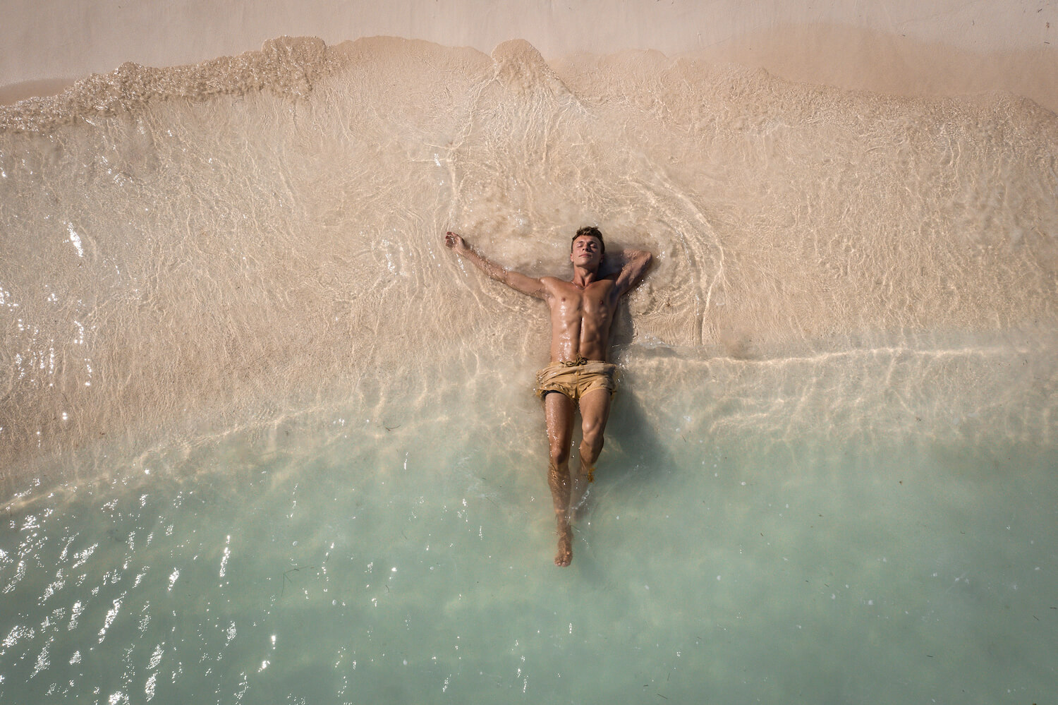 man lying on the sand in the mexican caribbean